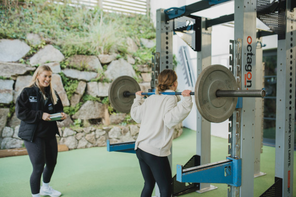 Health Club instructor providing barbell training to a member
