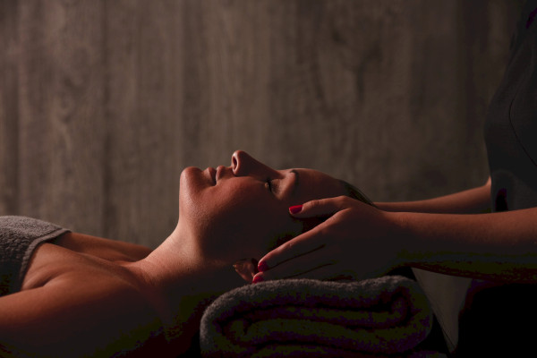 Aromatherapy Associates head and facial massage at St Michaels Spa Falmouth, therapist hands supporting guest during relaxing spa treatment